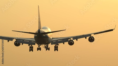 Tracking shot of landing jumbo jet at sunrise