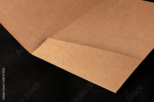 Brown kraft paper folder, a close-up of a pocket on a black background with a place for text