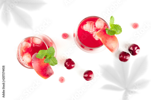 Vibrant red mocktails with fresh fruit and organic shadows, shot from the top on a white background with a place for text