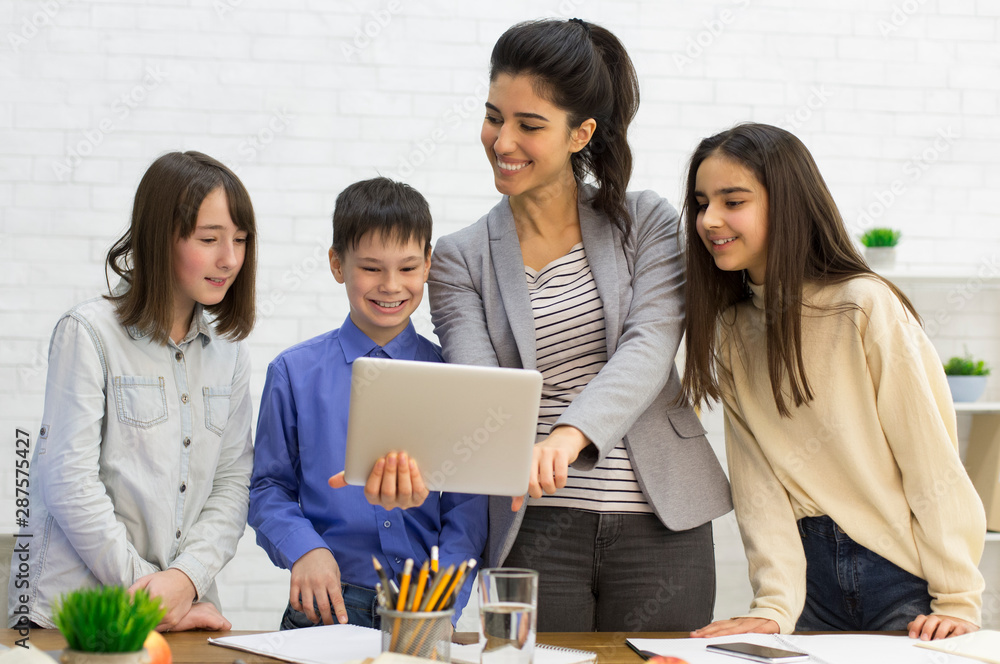 School kids with teacher looking on tablet School kids with teacher looking on tablet