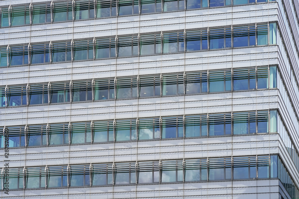 Glass blue square Windows of facade modern city business building skyscraper. Modern apartment buildings in new neighborhood. Windows of a building, texture.