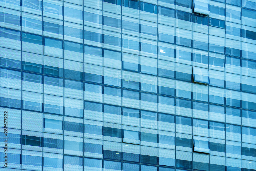 Glass blue square Windows of facade modern city business building skyscraper. Modern apartment buildings in new neighborhood. Windows of a building, texture. Glass blue square Windows of facade modern city business building skyscraper. Modern apartment buildings in new neighborhood. Windows of a building, texture.