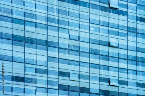 Glass blue square Windows of facade modern city business building skyscraper. Modern apartment buildings in new neighborhood. Windows of a building, texture.