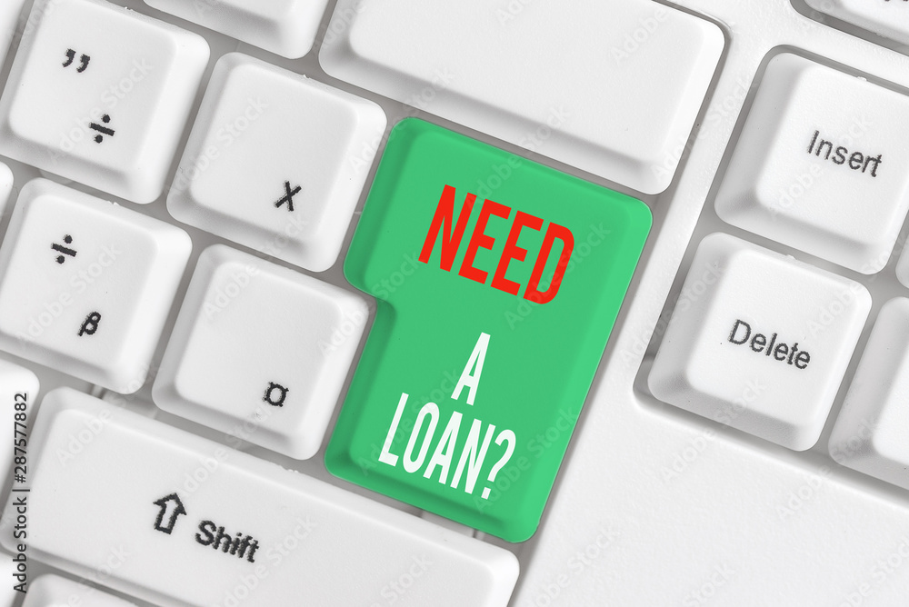 Text sign showing Need A Loan question. Business photo showcasing amount of money that is borrowed often from bank White pc keyboard with empty note paper above white background key copy space