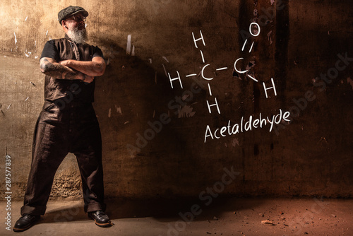 Bearded old man presenting handdrawn chemical formula of Acetic acid CH3COOH photo