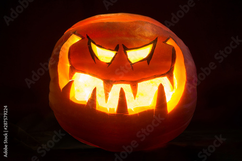 Halloween pumpkin smile and scrary eyes for party night. Black background