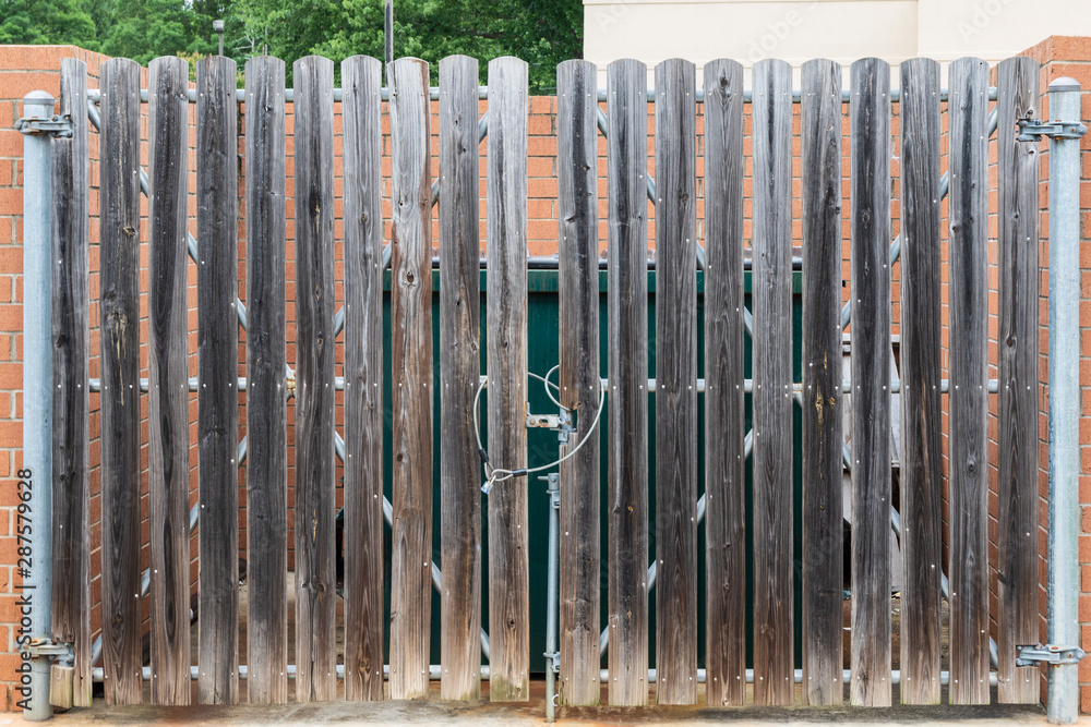Obraz premium Dumpster behind wood gate