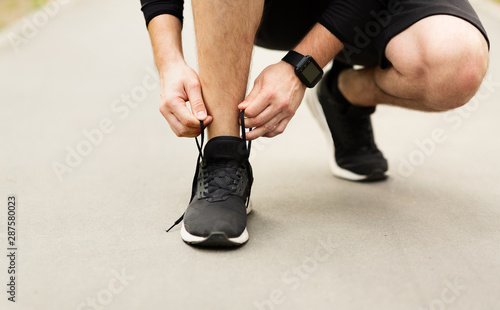 Man tying running shoes laces getting ready for run