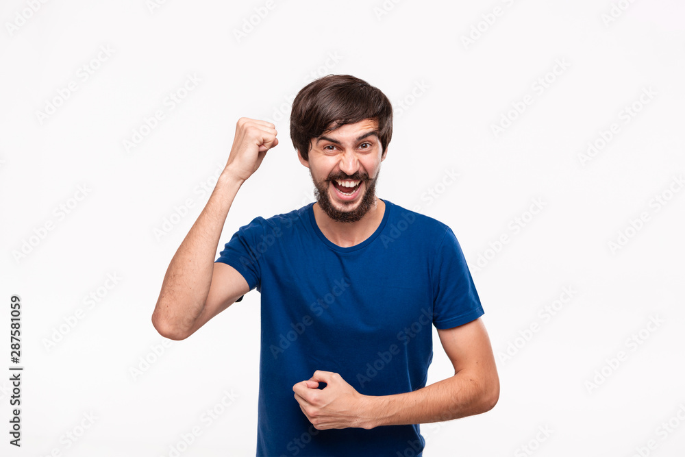 Young brunet bearded man with mustaches in a blue shirt posing expressing gesture of luck with his arms standing isolated over white background. Young brunet bearded man with mustaches in a blue shirt posing expressing gesture of luck with his arms standing isolated over white background.