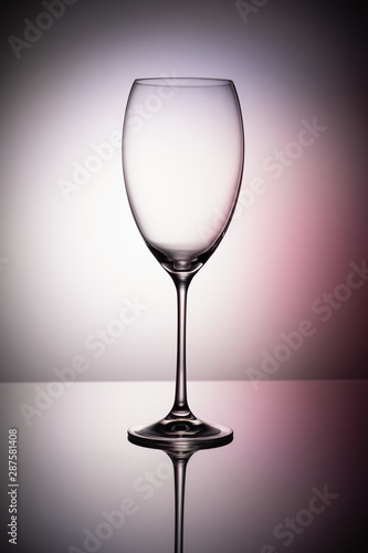 Empty wine glass goblets on a colored purple background abstract