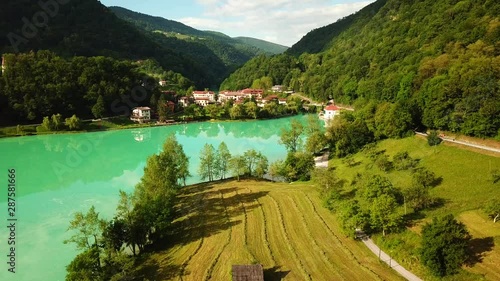 Forward drone shot above a slovenian valley, with a river flowing surrounded by mountains photo