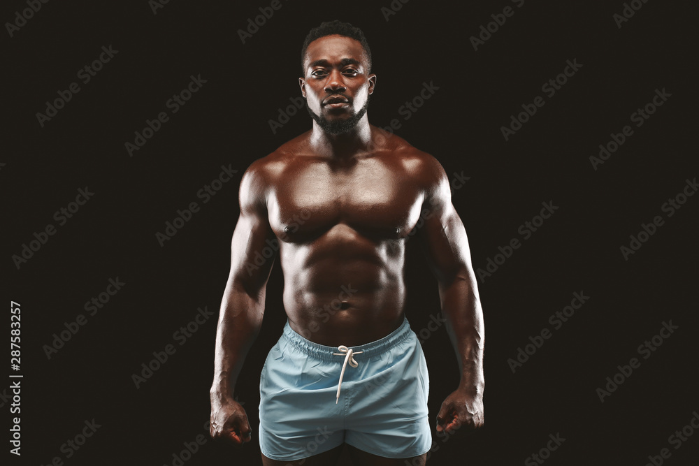 Strong athletic black man showing naked muscular body