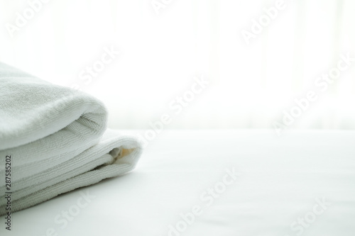 white towel on bed with see through curtain background.