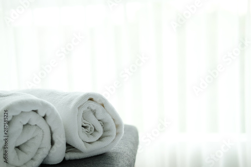 white towel on bed with see through curtain background.