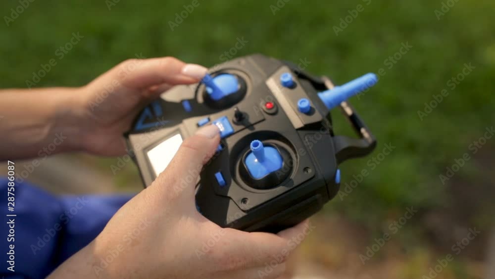Remote controller in female hands close-up. woman holding transmitter Remote controller in female hands close-up. woman holding transmitter