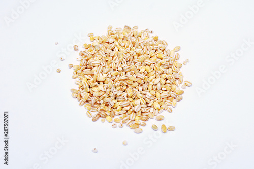 Barley heap surface close up macro isolated on white background. Organic healthy vegetarian food.