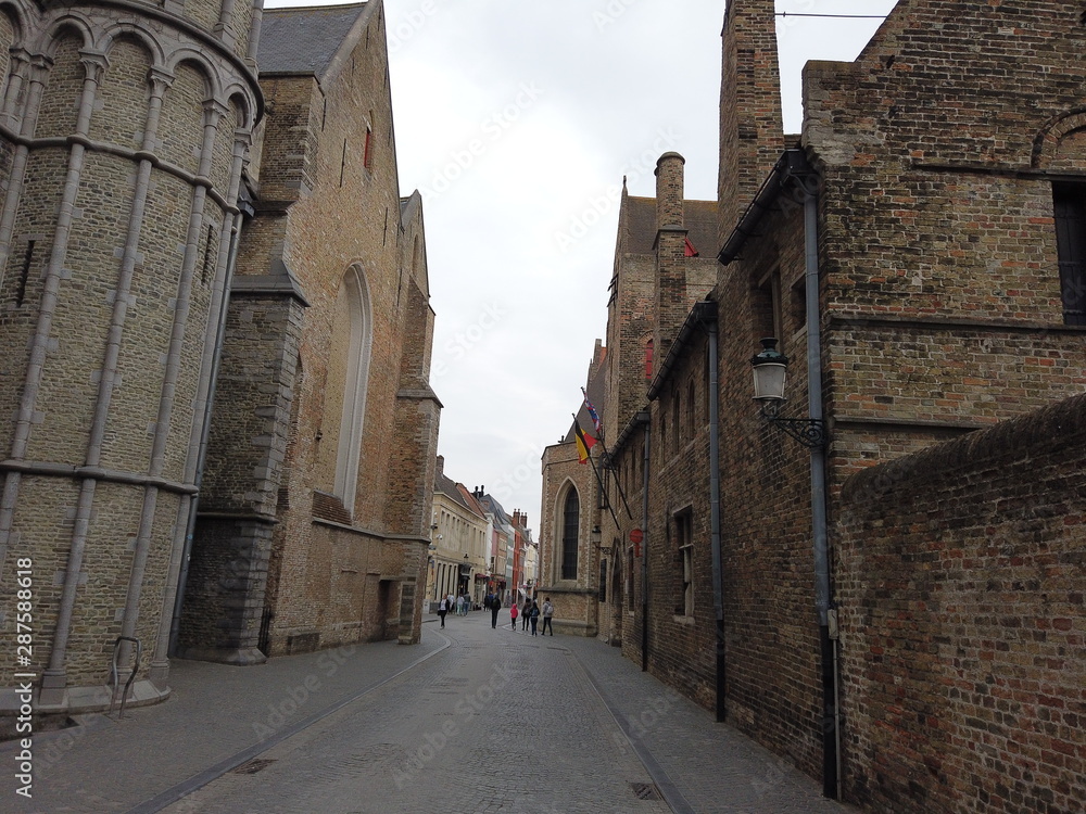 Bruges, Belgium - May 2019: View of the streets of the city. Tourists walk around the city. Ancient real estate.