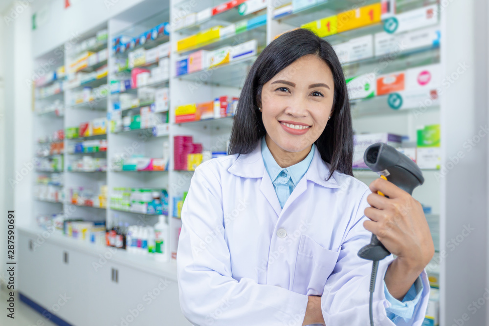 Happy Asian Pharmacist with barcode scanner in a pharmacy drugstore. Health business, Health care and medical concepts.