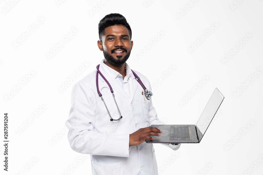 Portrait of a medical doctor standing in the studio while working with laptop, isolated on white background Portrait of a medical doctor standing in the studio while working with laptop, isolated on white background