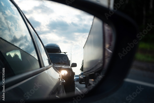View in the side mirror of a car on the road. Traffic congestion, a large congestion of cars, difficult traffic. © lusyaya