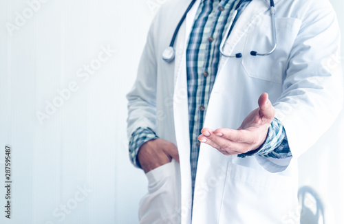 The doctor standing and put his hand in his pocket in the medical room for concept Ideal about diagnosis with modern medicine.