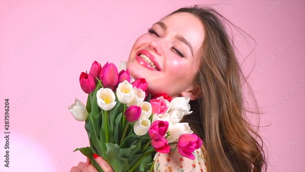 Beauty glamour girl with spring tulip flowers. Beautiful young woman with a bunch of colorful tulip flowers. Happy model posing with bouquet of tulips. Slow Motion 4K UHD video footage. 3840X2160 Beauty glamour girl with spring tulip flowers. Beautiful young woman with a bunch of colorful tulip flowers. Happy model posing with bouquet of tulips. Slow Motion 4K UHD video footage. 3840X2160