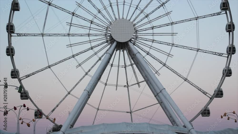 Ferris wheel rotates at sunset under a beautiful sky Ferris wheel rotates at sunset under a beautiful sky