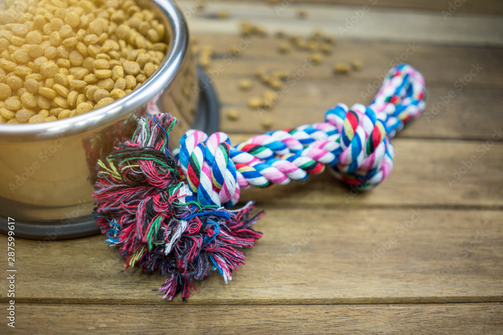 Pet toy and dry food for dog or cat on wooden table Pet toy and dry food for dog or cat on wooden table