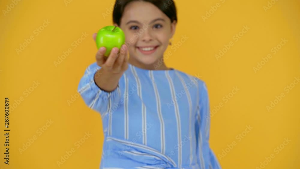 happy child showing green apple isolated on yellow happy child showing green apple isolated on yellow