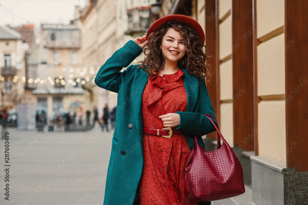 Happy smiling fashionable curvy woman wearing trendy autumn outfit