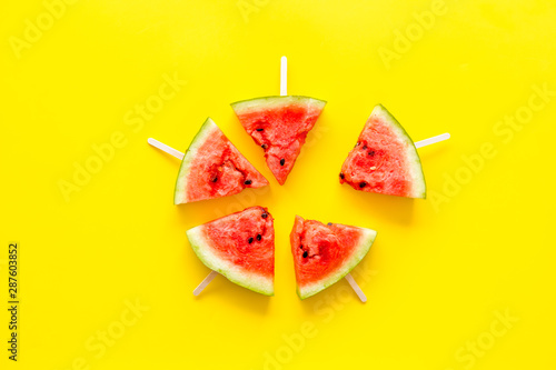 Popsicle from fresh watermelon on yellow background top view