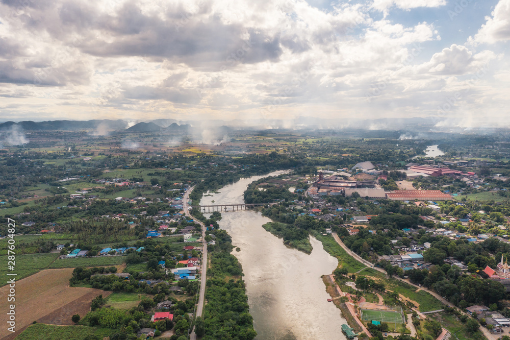 Village on coast with river and sugar process factory and smoke in plantation