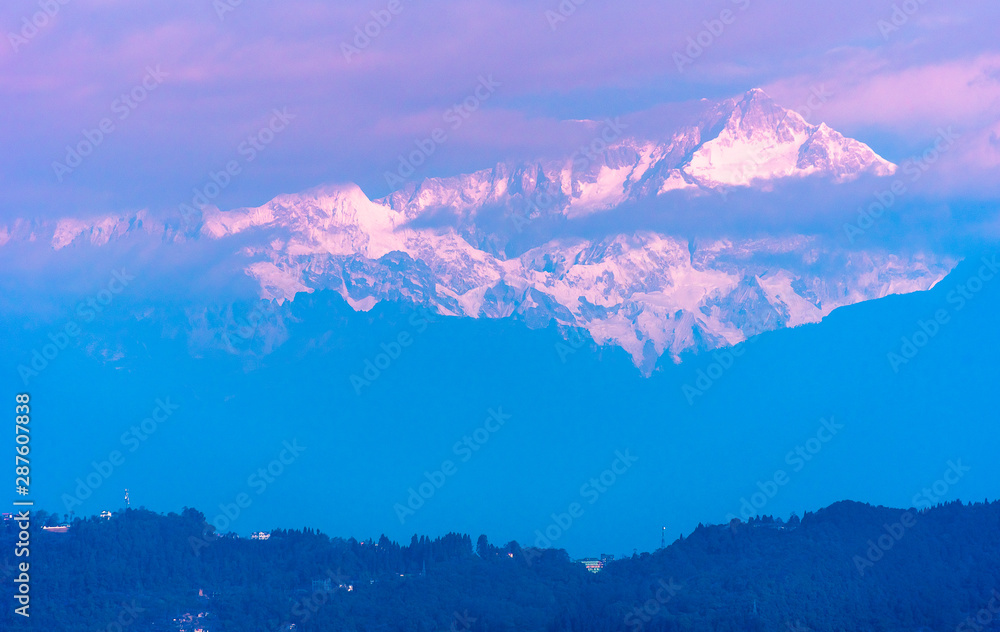 Fototapeta premium A view of Snow clad Kanchenjunga,the third highest mountain in the world, covered with clouds.