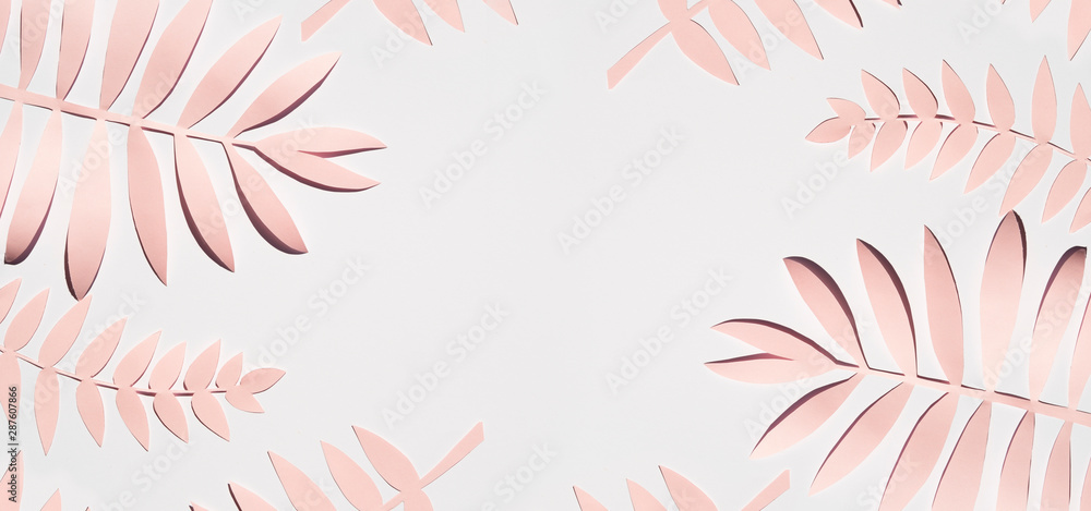 Flat lay pink paper palm leaves on gray background. Summer frame mockup. Copy space