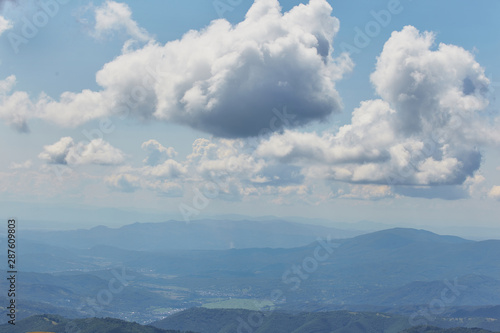 Fototapeta Naklejka Na Ścianę i Meble -  Cloud landscape with blue silhouettes of mountains.