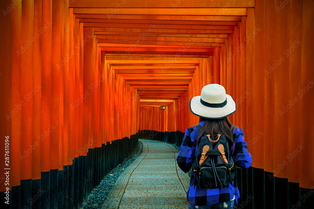 Woman traveler with backpack at fushimi inari taisha shrine in Kyoto, Japan. - obrazy, fototapety, plakaty 