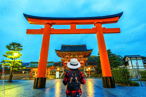 Woman traveler with backpack at fushimi inari taisha shrine in Kyoto, Japan.
