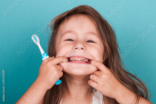 Fototapeta Cute little girl brushing her teeth