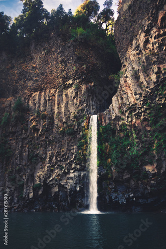 cascada ubicada entre rocas volc  nicas