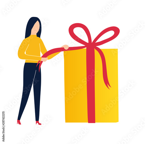 The girl opens a gift. Pulling a ribbon to untie a bow on a gift box