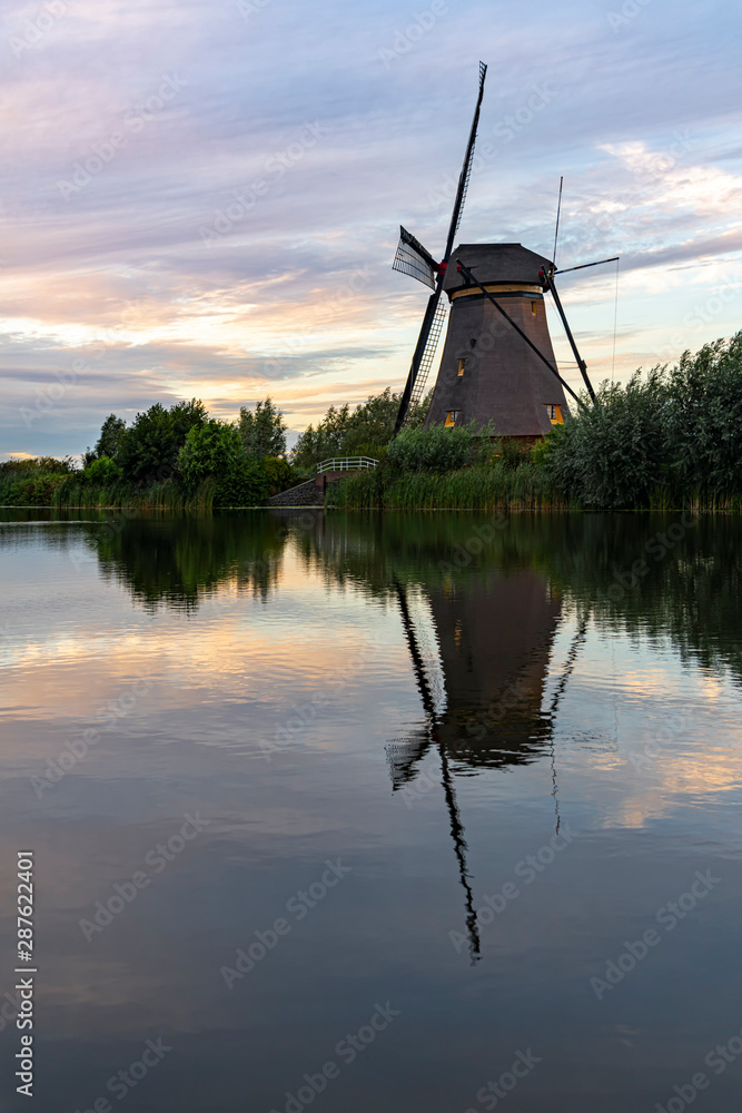 Dutch windmill reflected on the early sunset lights