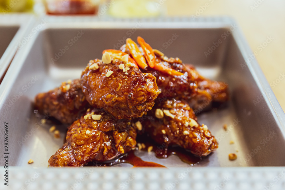 Close-up Golden Crunchy Korean Fried Chicken (basic Huraideu-Chikin) mix with spicy sauce and garlic. In South Korea, fried chicken is consumed as a meal, an appetizer. Close-up Golden Crunchy Korean Fried Chicken (basic Huraideu-Chikin) mix with spicy sauce and garlic. In South Korea, fried chicken is consumed as a meal, an appetizer.