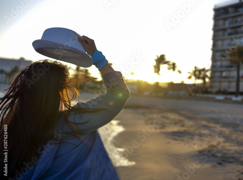 Attractive brunette girl runs in the evening at sunset along the beach
