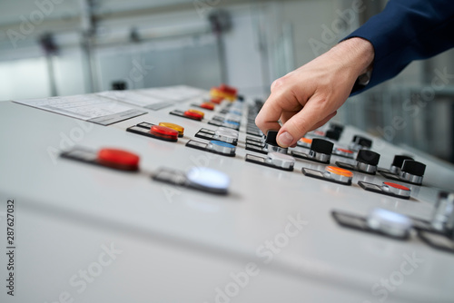 Close-up of hand operating control panel photo