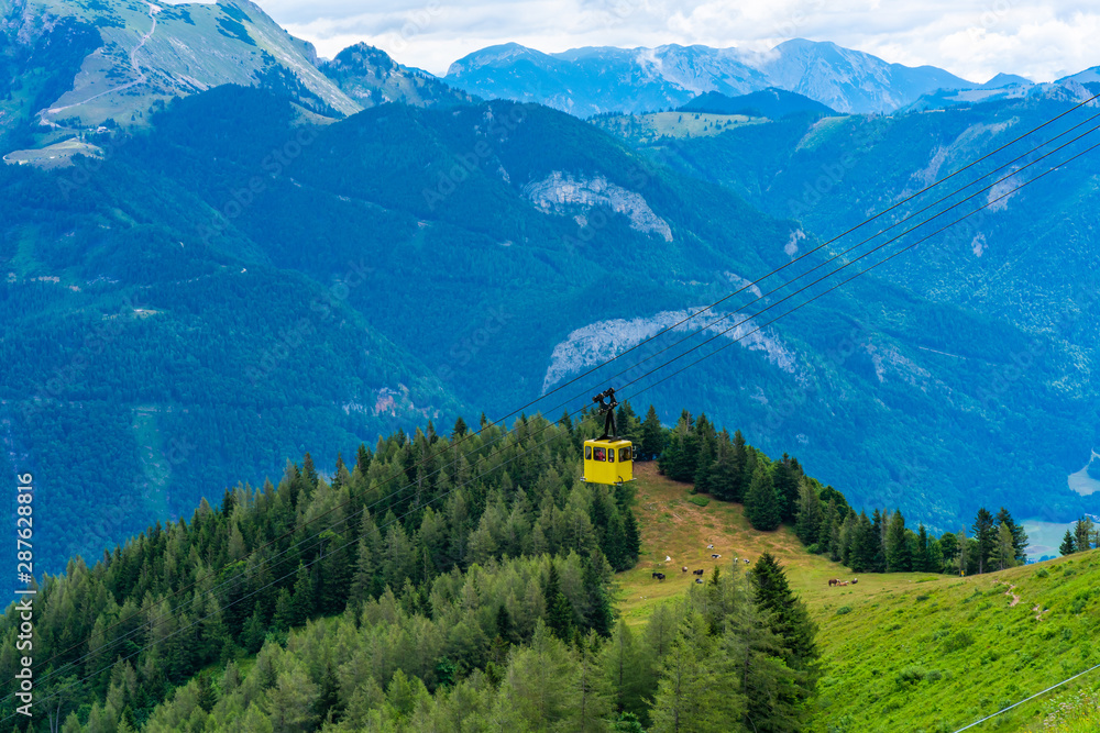 View of valliies, mountains and yellow Seilbahn cable car gondola from Zwolferhorn mountain in St. Gilgen in Salzkammergut region, Austria