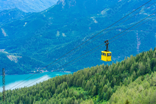 View of Wolfgangsee lake, surrounding mountains and yellow Seilbahn cable car gondola from Zwolferhorn mountain in St. Gilgen in Salzkammergut region, Austria