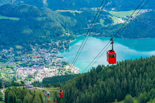 View of St.Gilgen village, Wolfgangsee lake and red Seilbahn cable car gondolas from Zwolferhorn mountain in Salzkammergut region, Austria