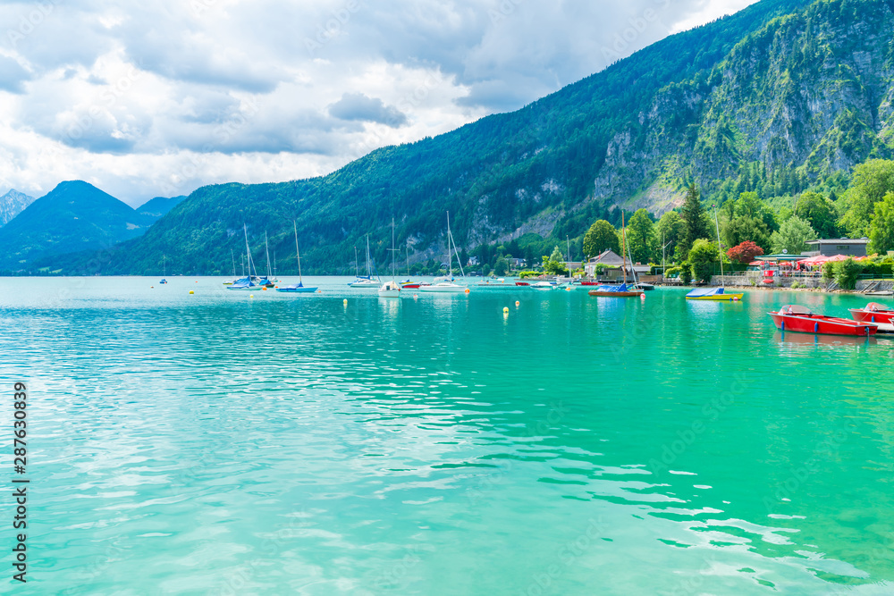 ST. GILGEN, AUSTRIA - JULY 12, 2019: Boats on Wolfgangsee lake in Sankt Gilgen village in a well-known travel destination of Salzkammergut resort region in Austria