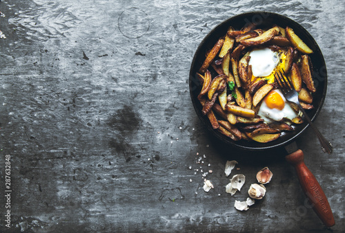 Fried potatoes and eggs in a pan close-up. horizontal photo