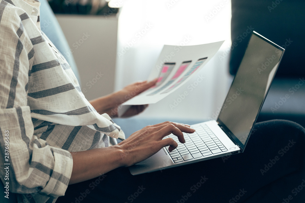 Fototapeta premium Young adult woman holding sketch with app interface in hand